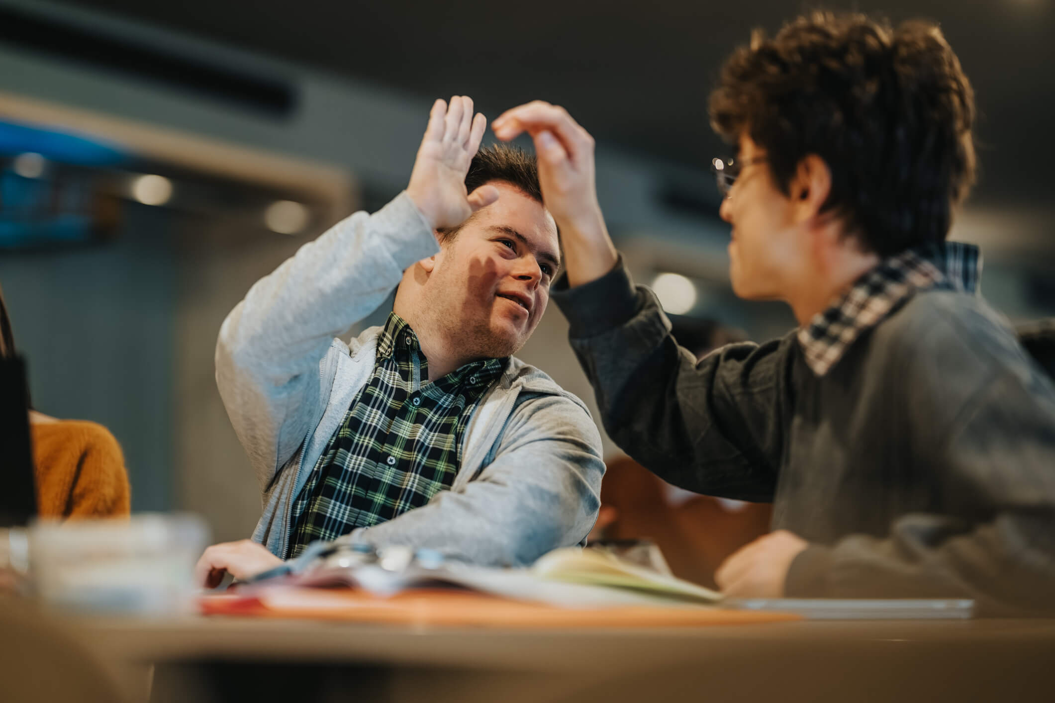 person with downs syndrome high fiving friend